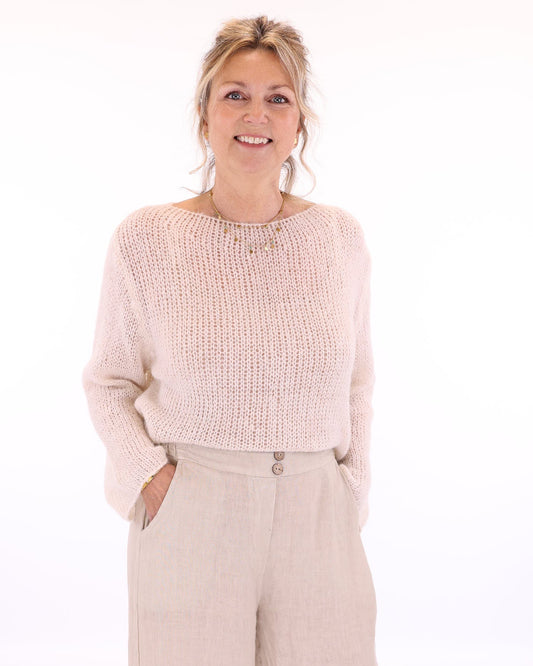 Women's long sleeve cobweb knitted alpaca blend sweater in cream, worn with cream linen trousers, made in Italy