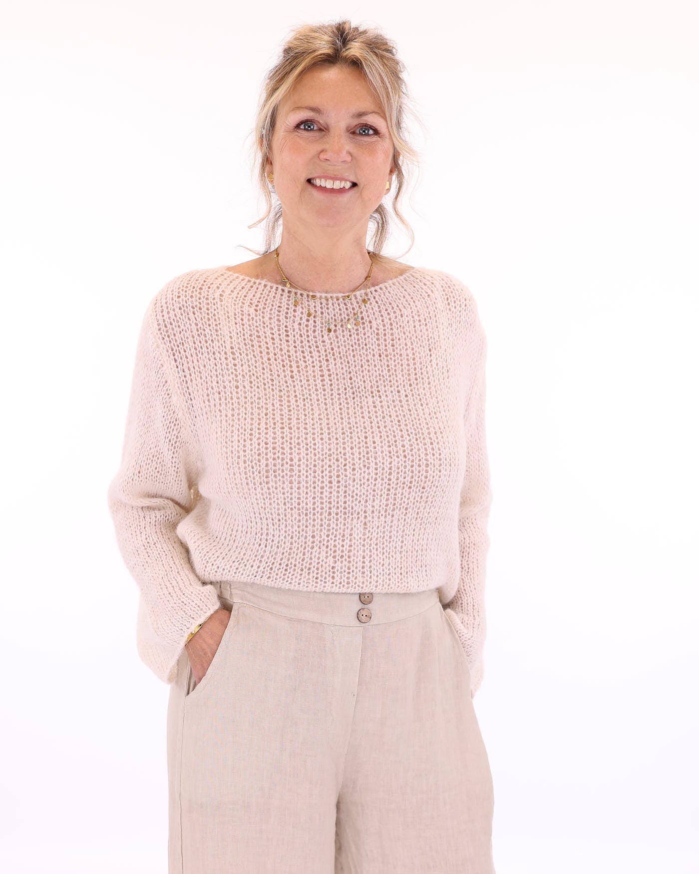 Women's long sleeve cobweb knitted alpaca blend sweater in cream, worn with cream linen  trousers, made in Italy