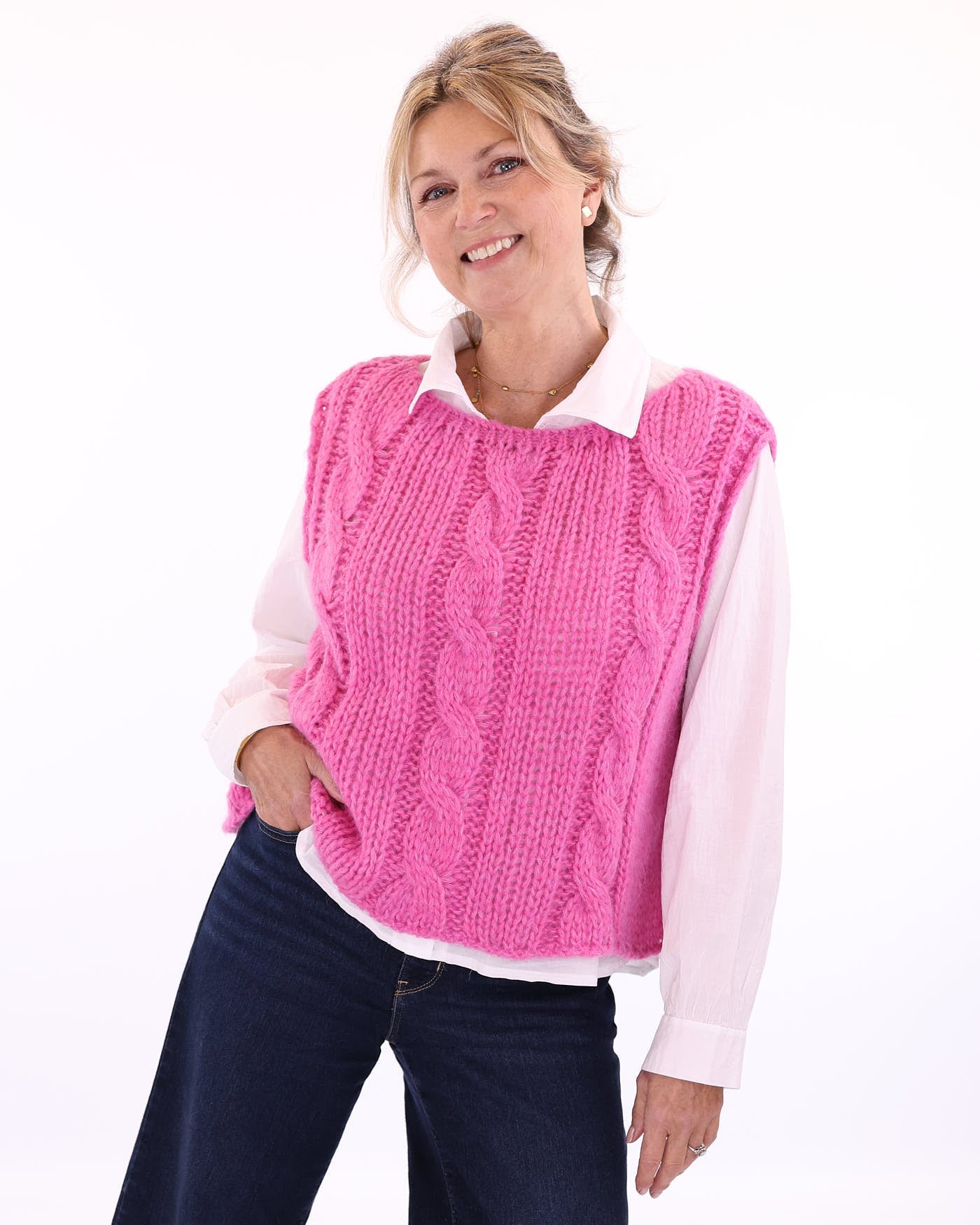 Women's alpaca blend cable knit tank top for Spring/Summer in fuchsia pink, worn over a white long sleeve shirt with a collar, made in Italy