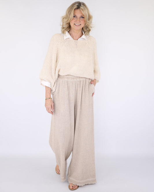 Women's Italian Linen Full Length Trousers with pockets and a frayed hem in cream, worn with an alpaca three quarter sleave jumper in cream